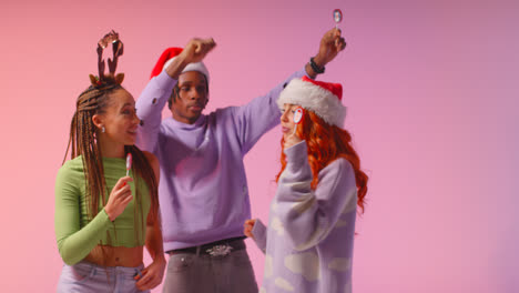 Studio-Shot-Of-Gen-Z-Friends-Dancing-At-Christmas-Party-Wearing-Santa-Hat-And-Reindeer-Antlers-2
